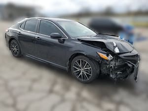 2021 Toyota Camry SE sedan with front-end collision damage at a salvage auction